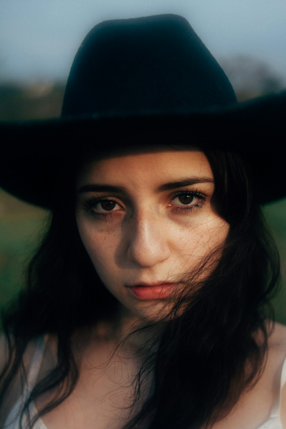 a woman wearing a black hat with long hair