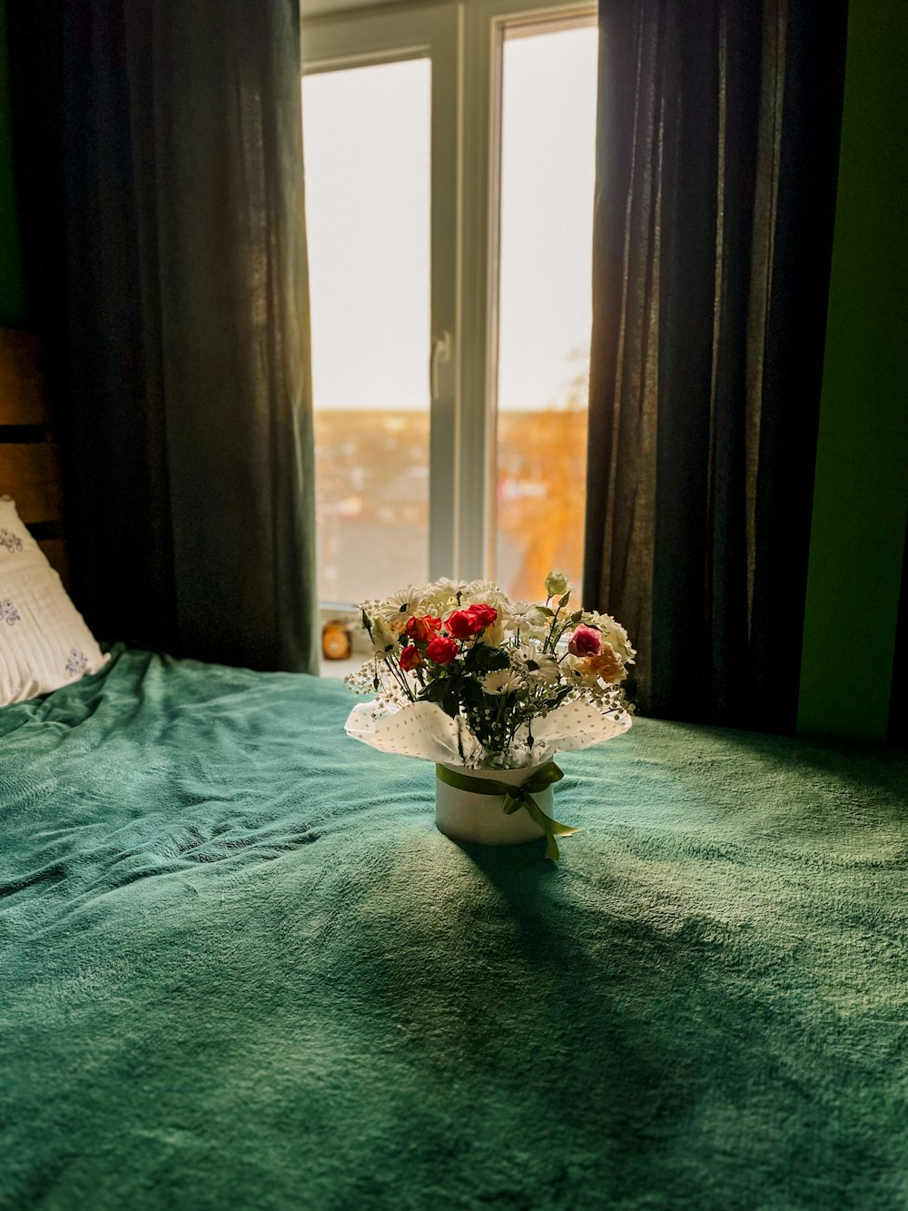 a vase of flowers sitting on top of a bed