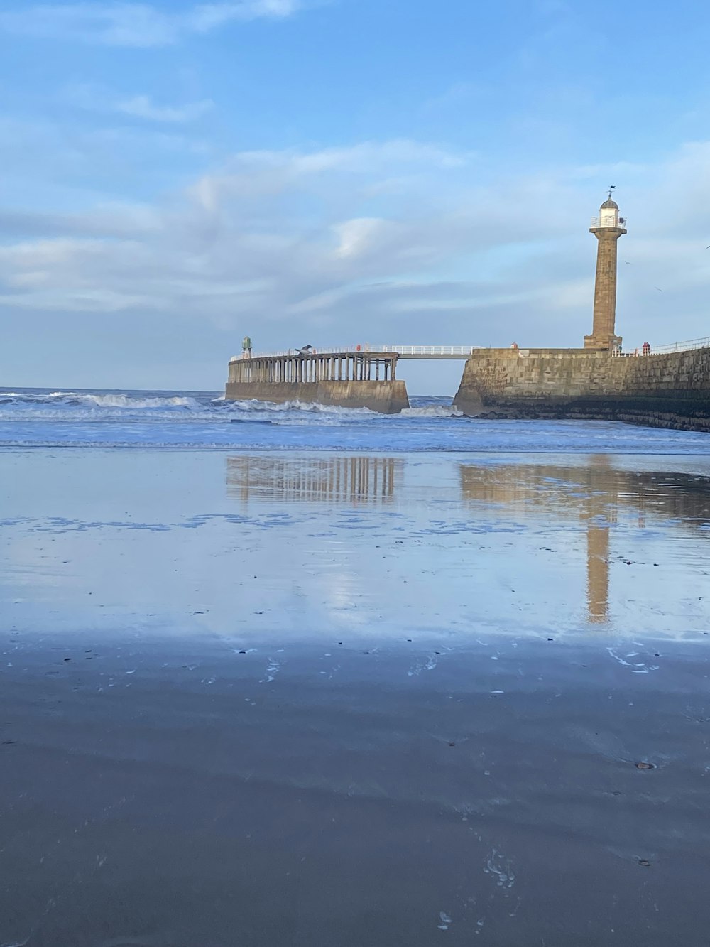 a beach with a light house in the distance