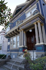 A stunning exterior of a high-end home featuring classic architectural details with gold and light blue accents.