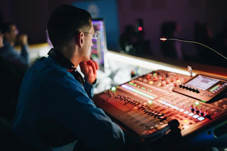 a man sitting in front of a sound board