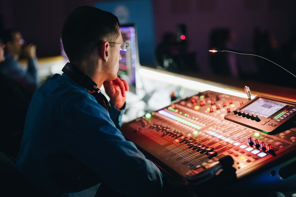 a man sitting in front of a sound board