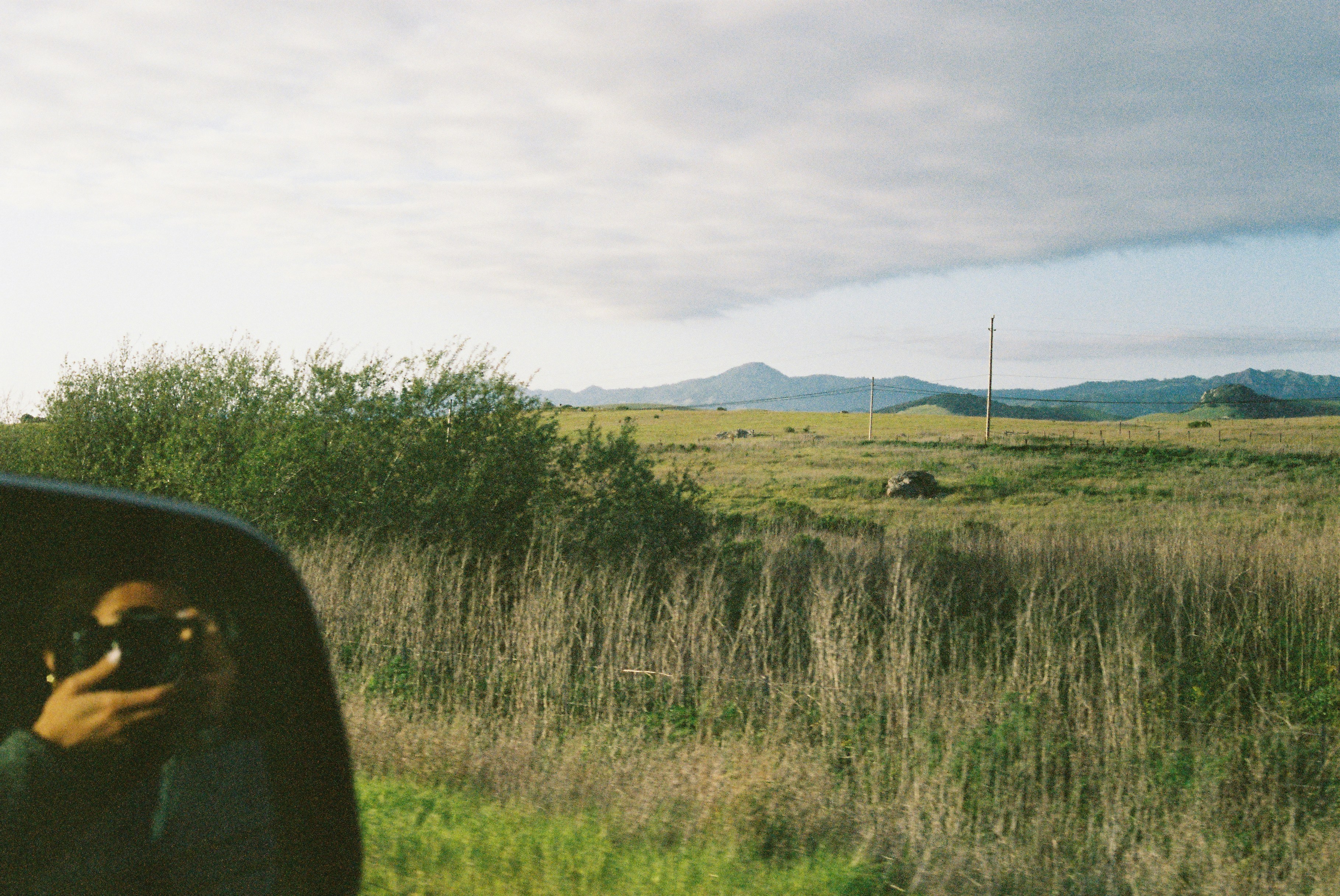 a man taking a picture of himself in the side mirror of a car
