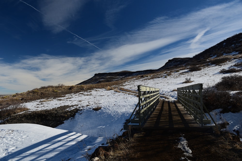 Un puente de madera sobre una colina cubierta de nieve