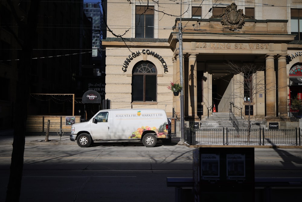 a white van parked in front of a building