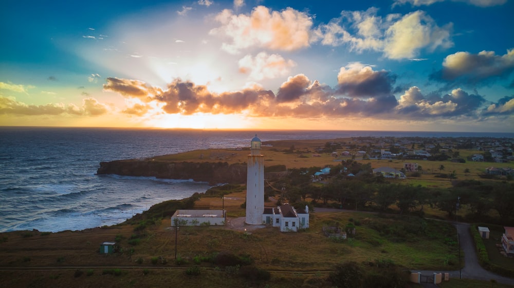 a light house sitting on top of a lush green hillside