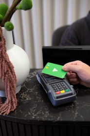 a person holding a green card next to a calculator