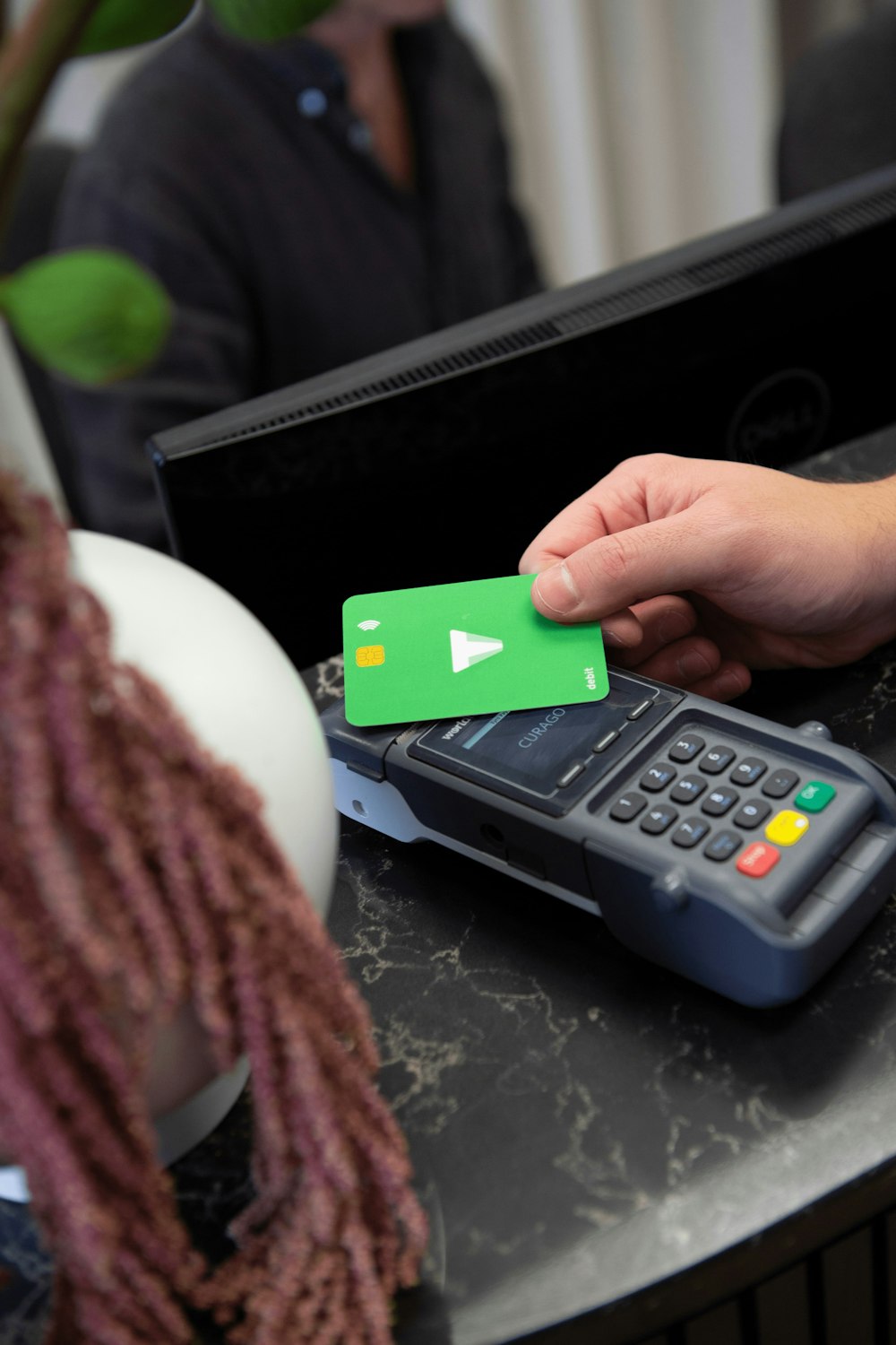 a person holding a green card next to a calculator