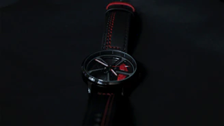 Sleek contemporary watch with a black metal band showcased against a dark background.