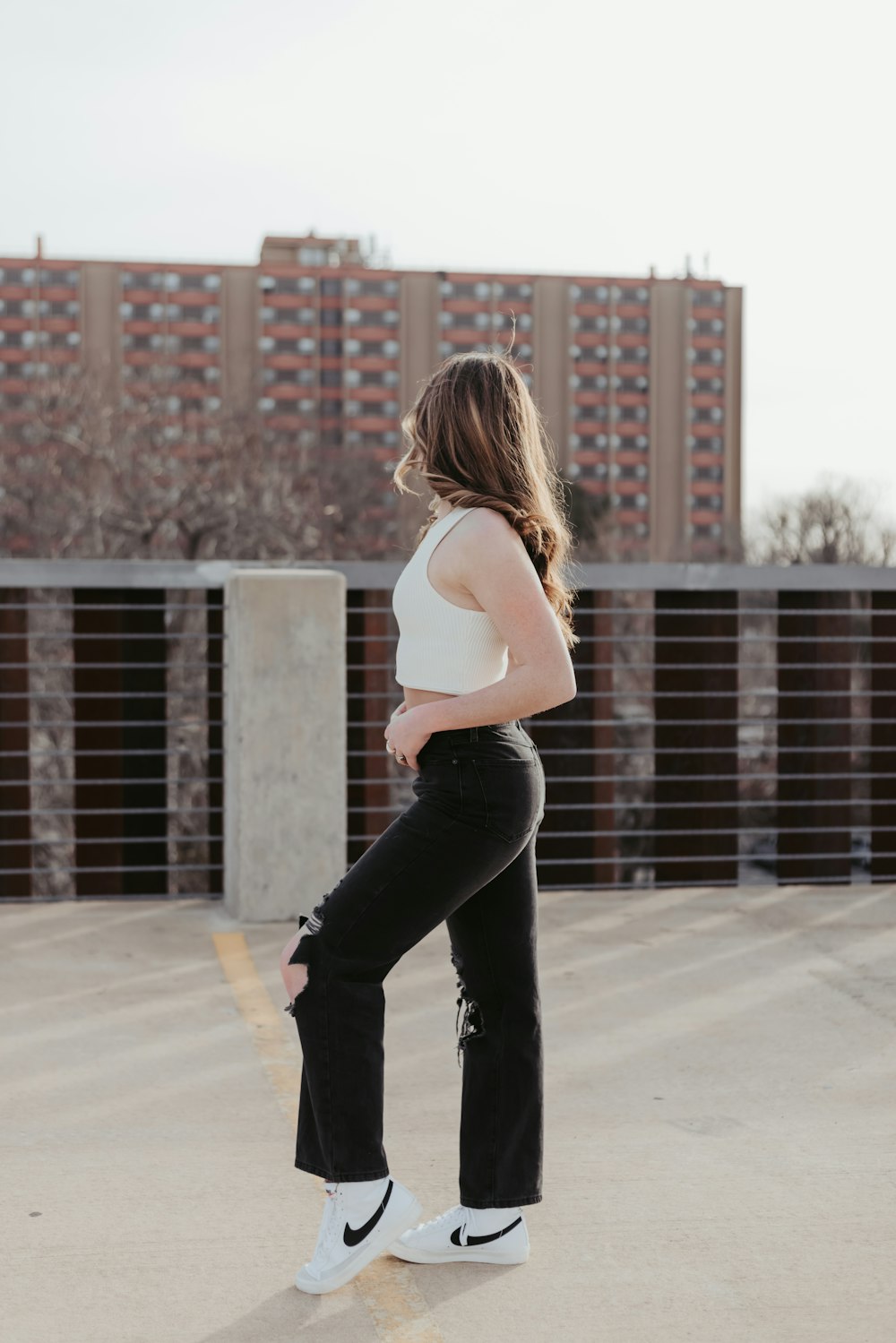 a woman in black jeans and a white tank top