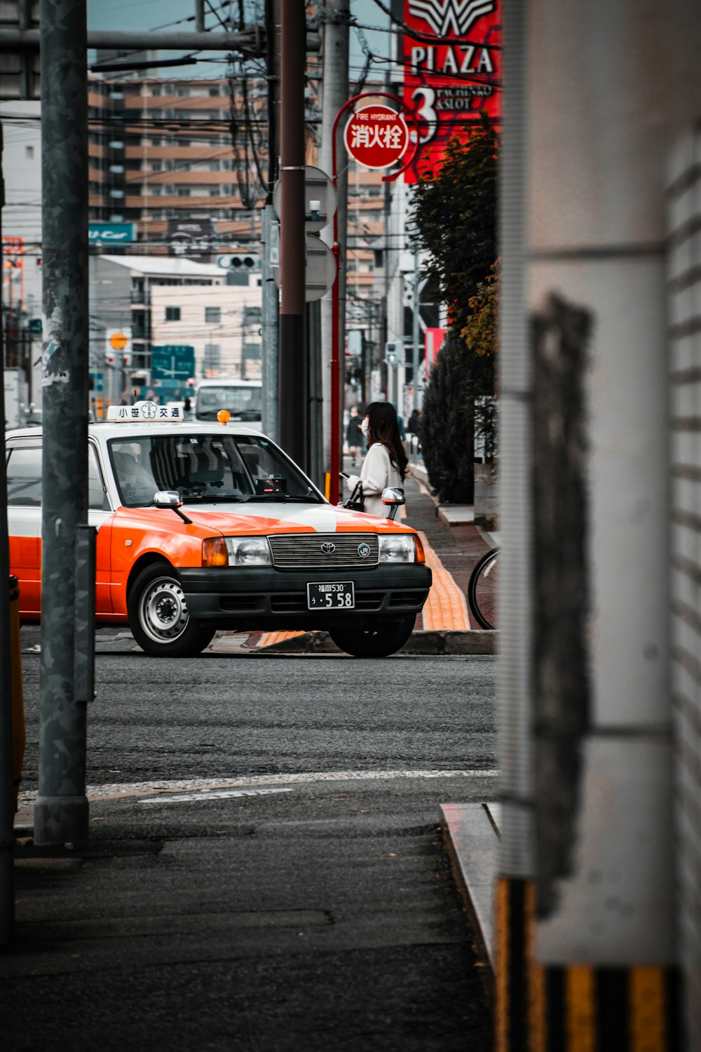 an orange and white car driving down a street