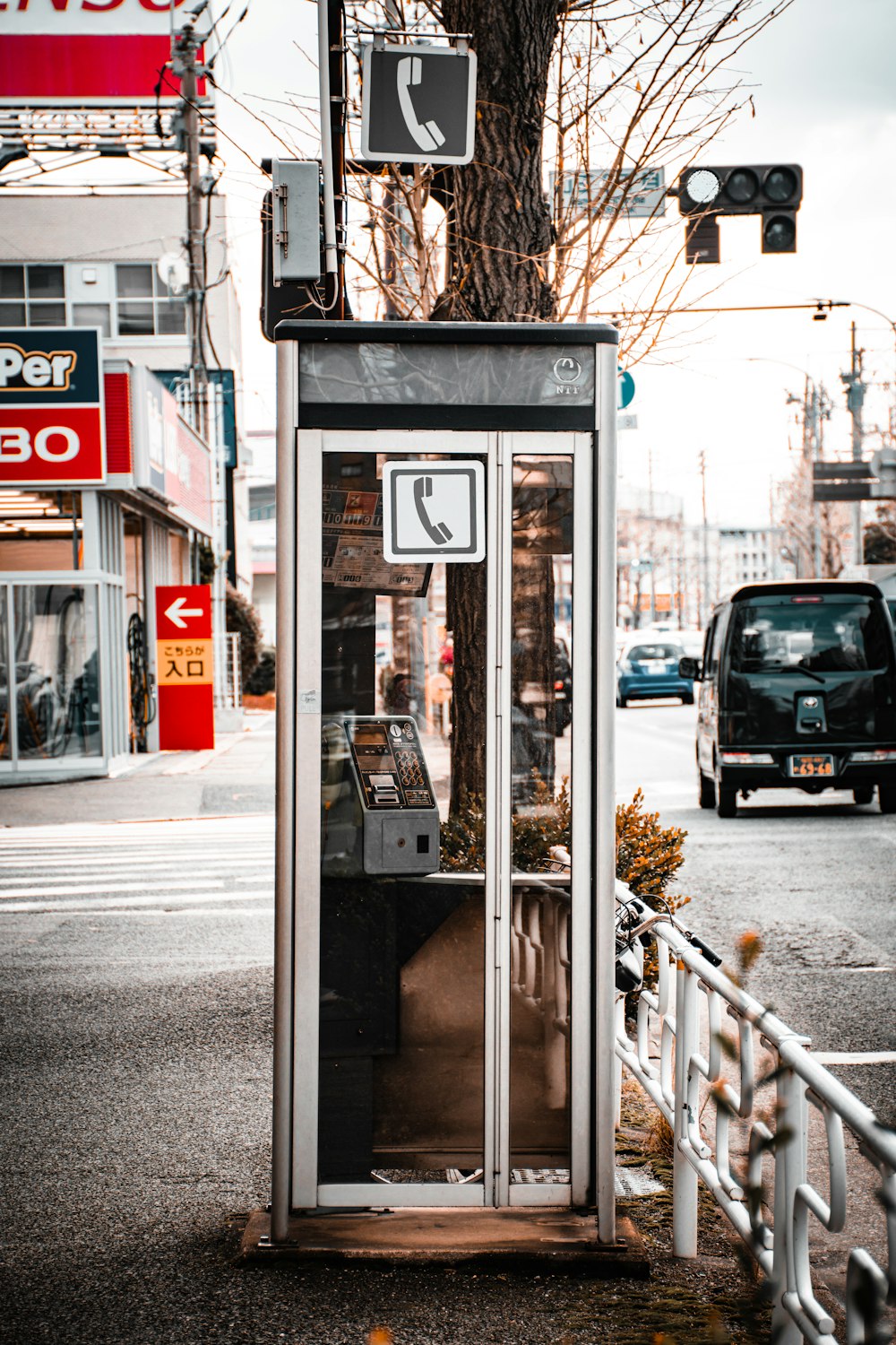 a phone booth sitting on the side of a road