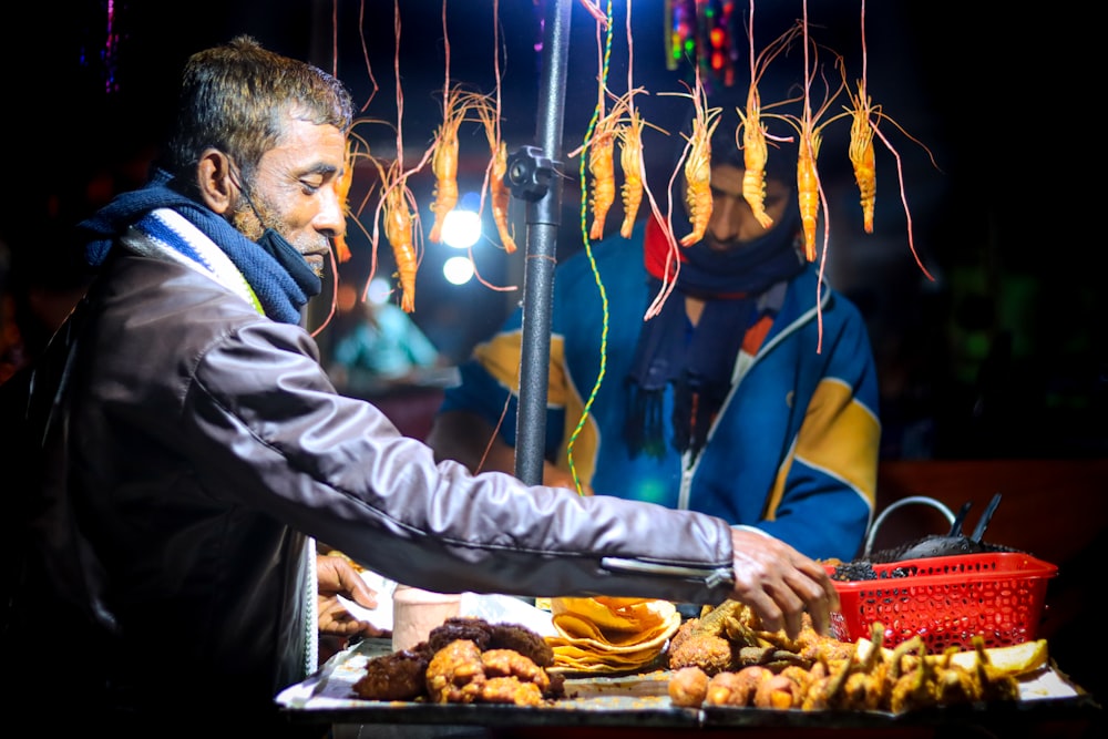 a man standing in front of a table filled with food