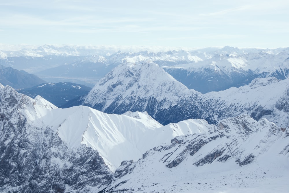 a mountain range covered in snow with mountains in the background