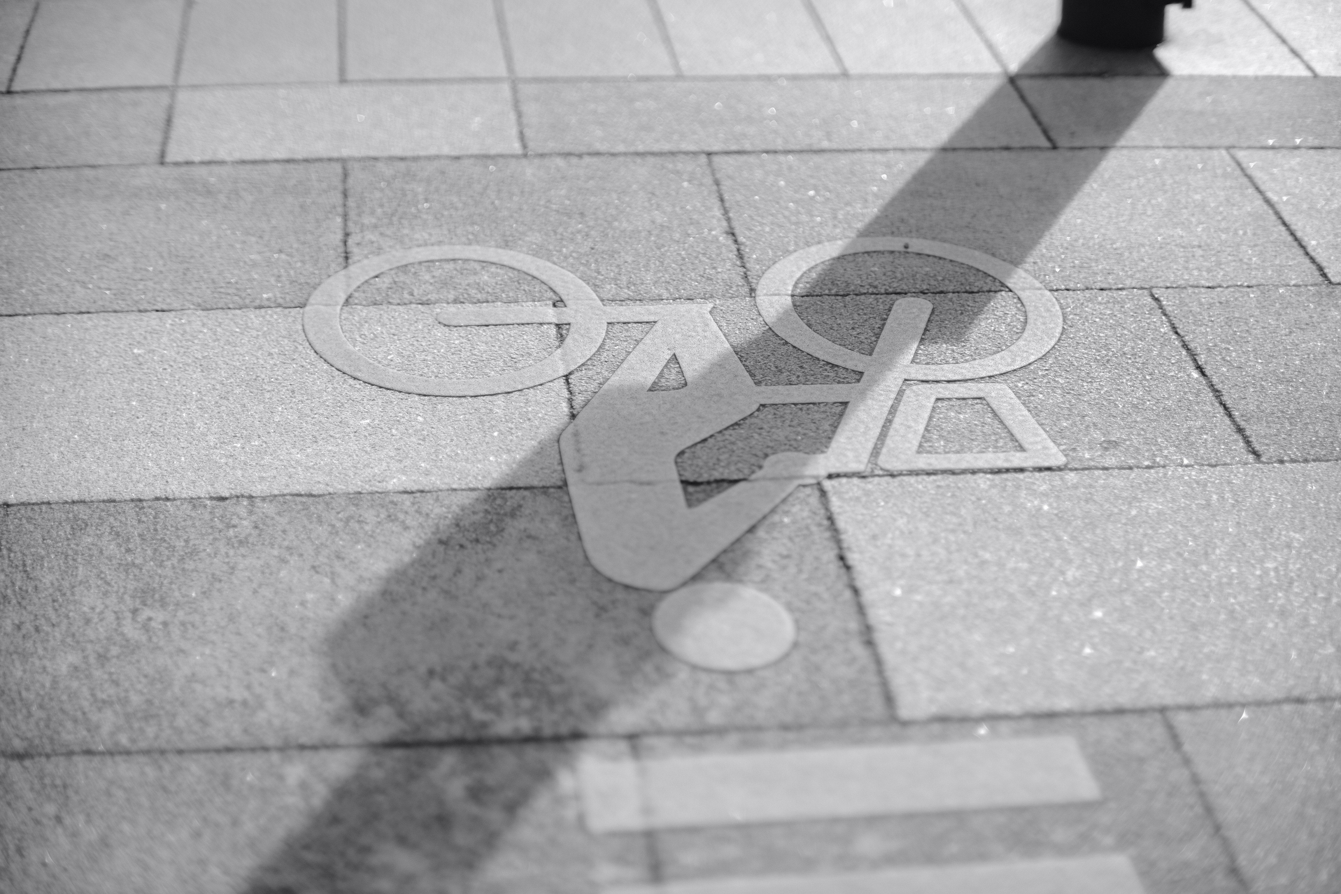 a black and white photo of a person walking on a sidewalk