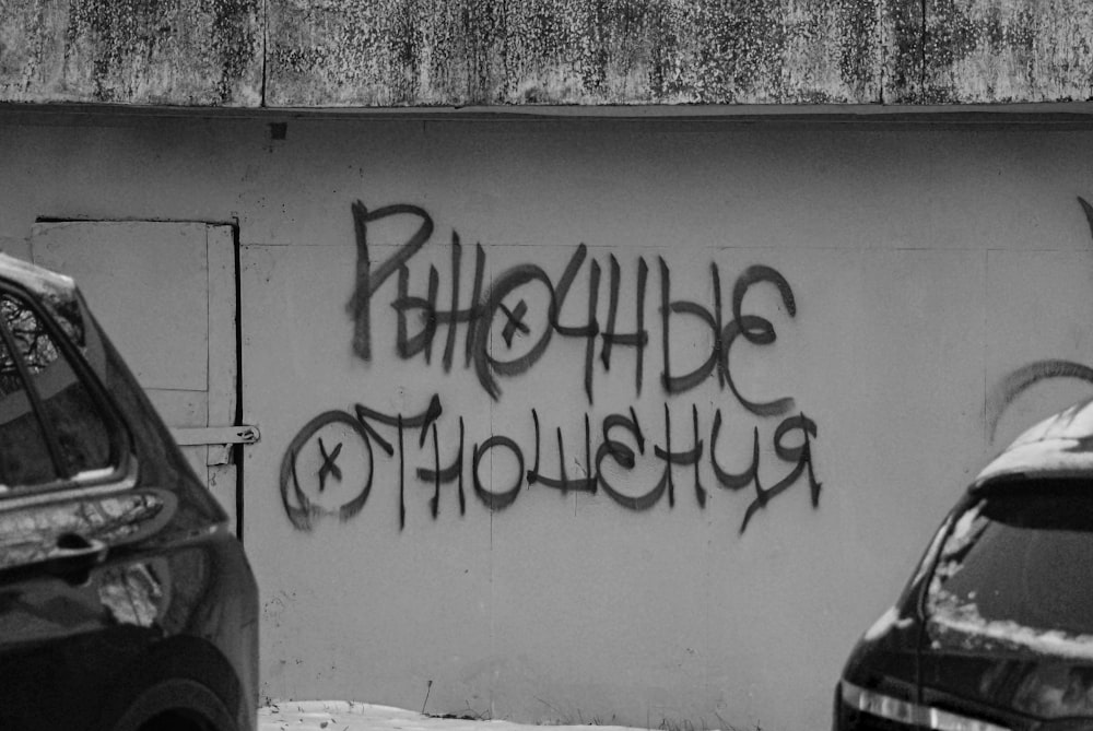 a black and white photo of graffiti on a wall