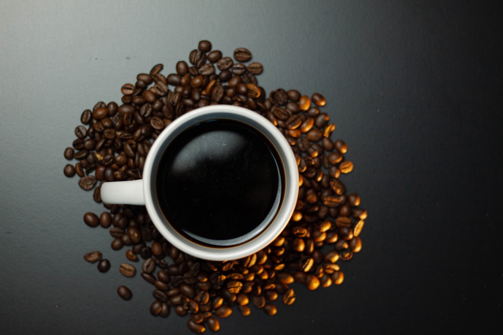 a cup of coffee surrounded by coffee beans