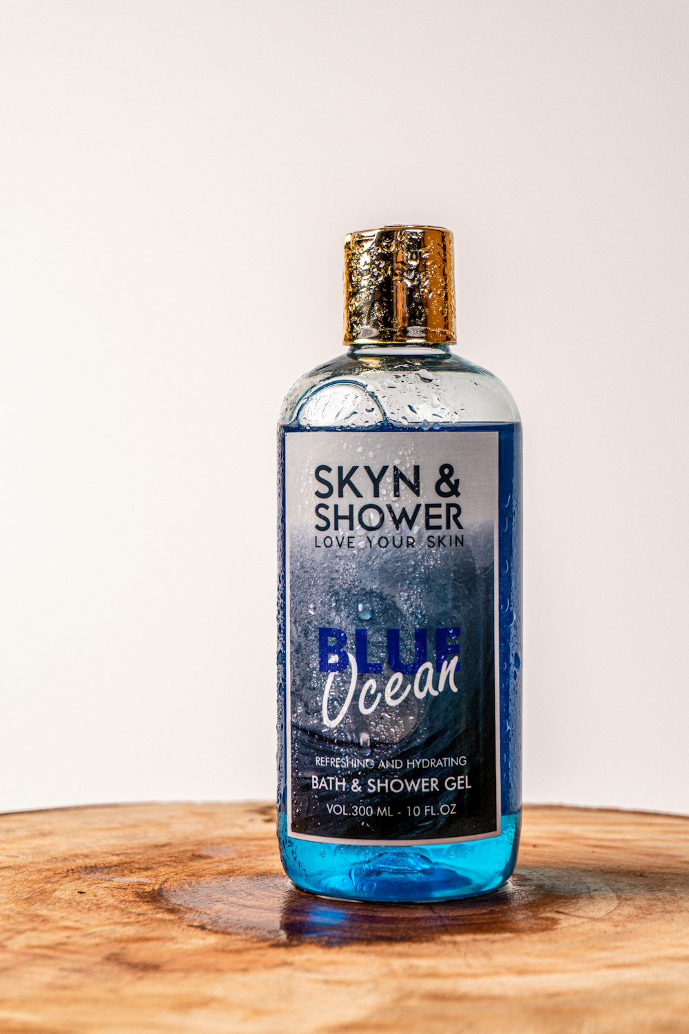 a bottle of blue ocean water sitting on top of a wooden table