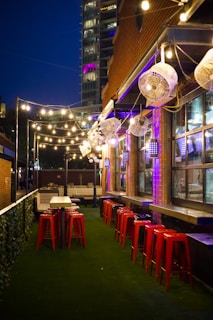 Outdoor bar seating with string lights glowing at dusk in São Paulo
