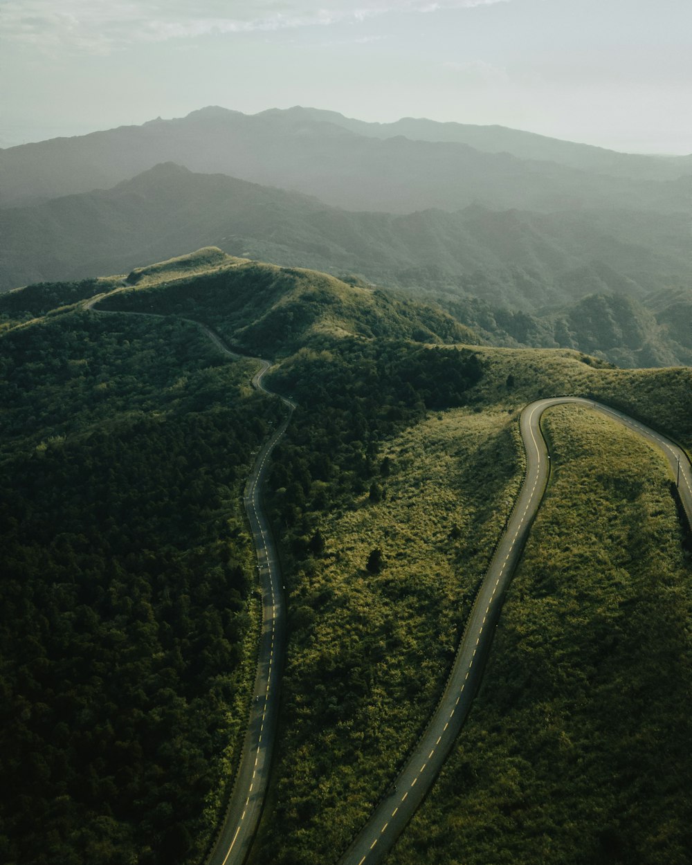 an aerial view of a winding road in the mountains