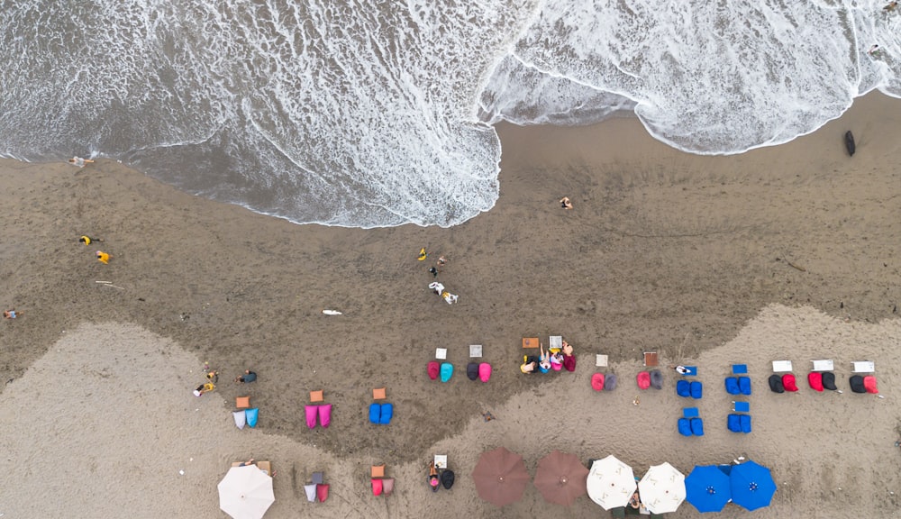 an aerial view of a beach with umbrellas and chairs