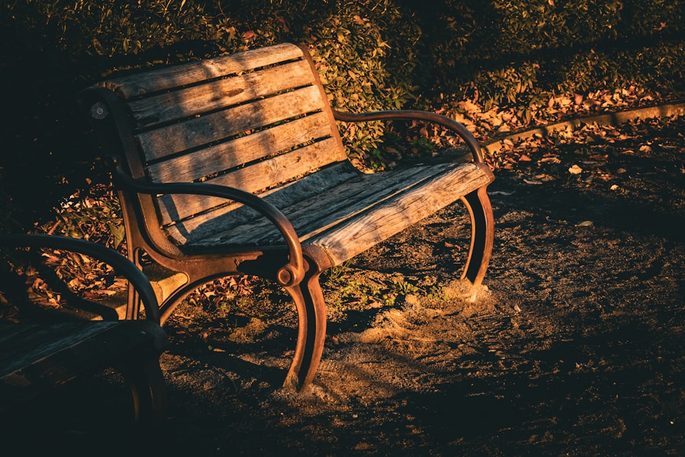 a wooden bench sitting on top of a dirt field