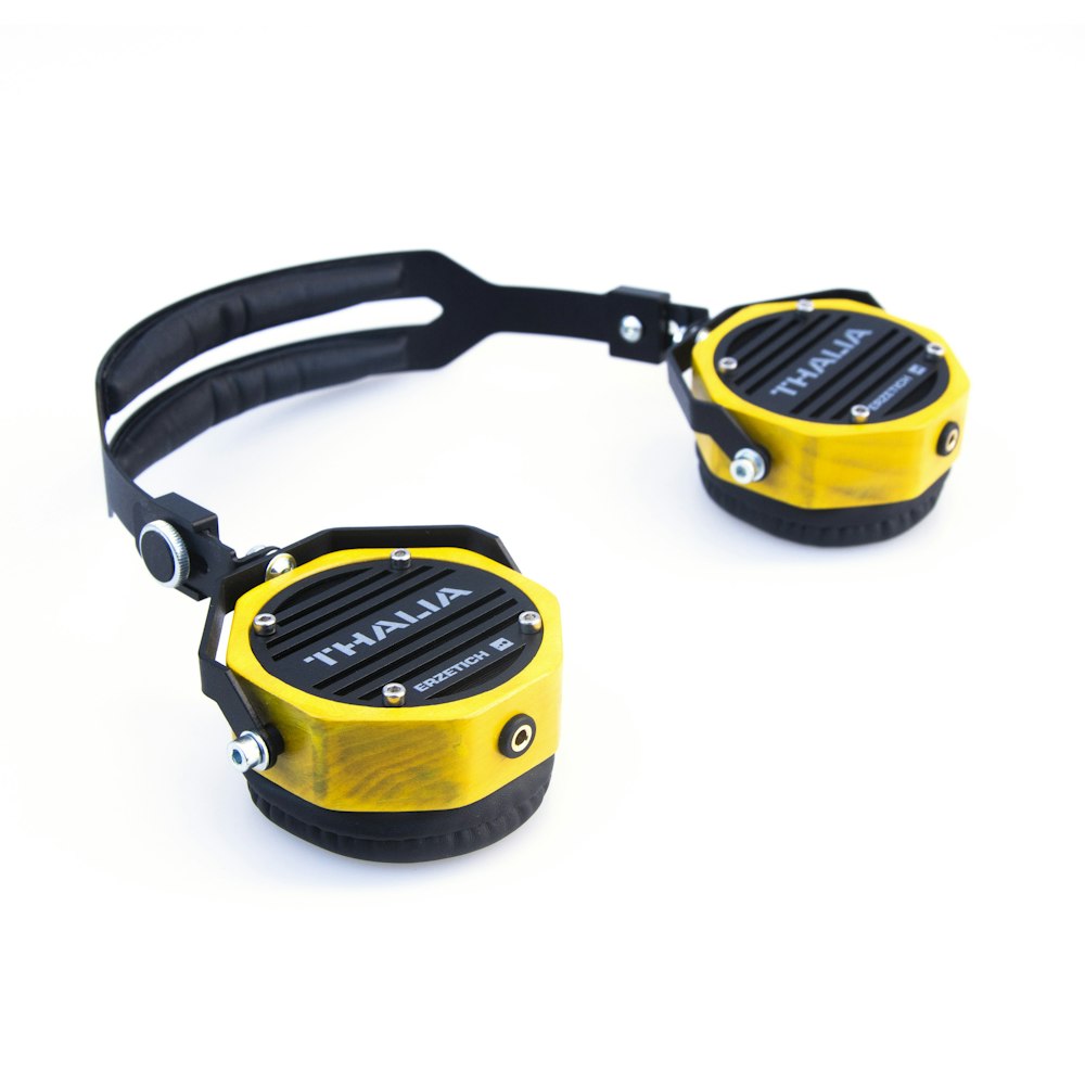 a pair of yellow and black headphones on a white background