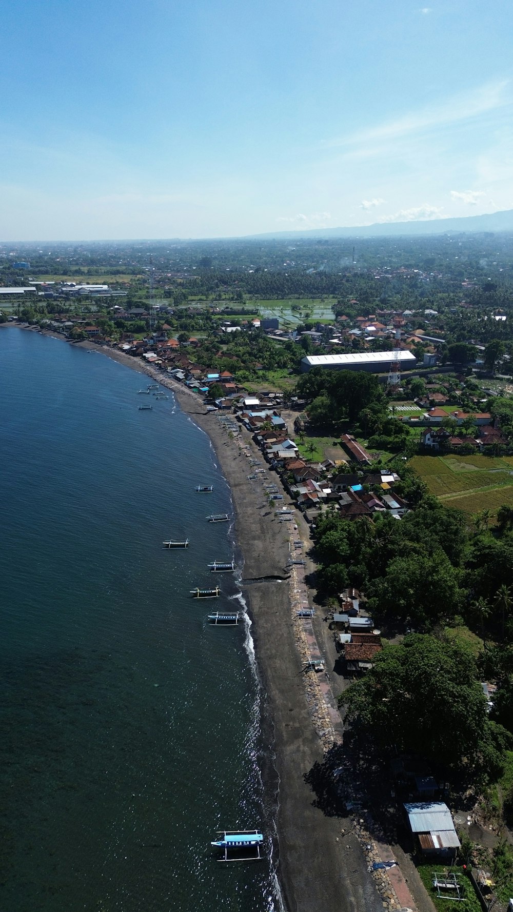 an aerial view of a beach with boats in the water