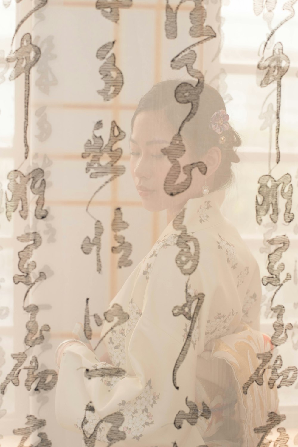 a woman in a kimono looking out of a window