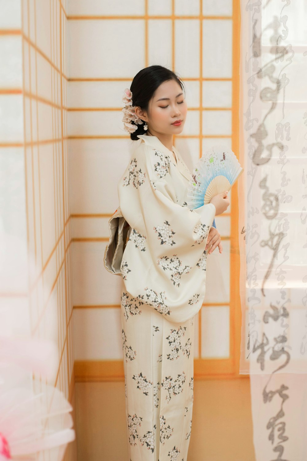 a woman in a kimono holding a fan