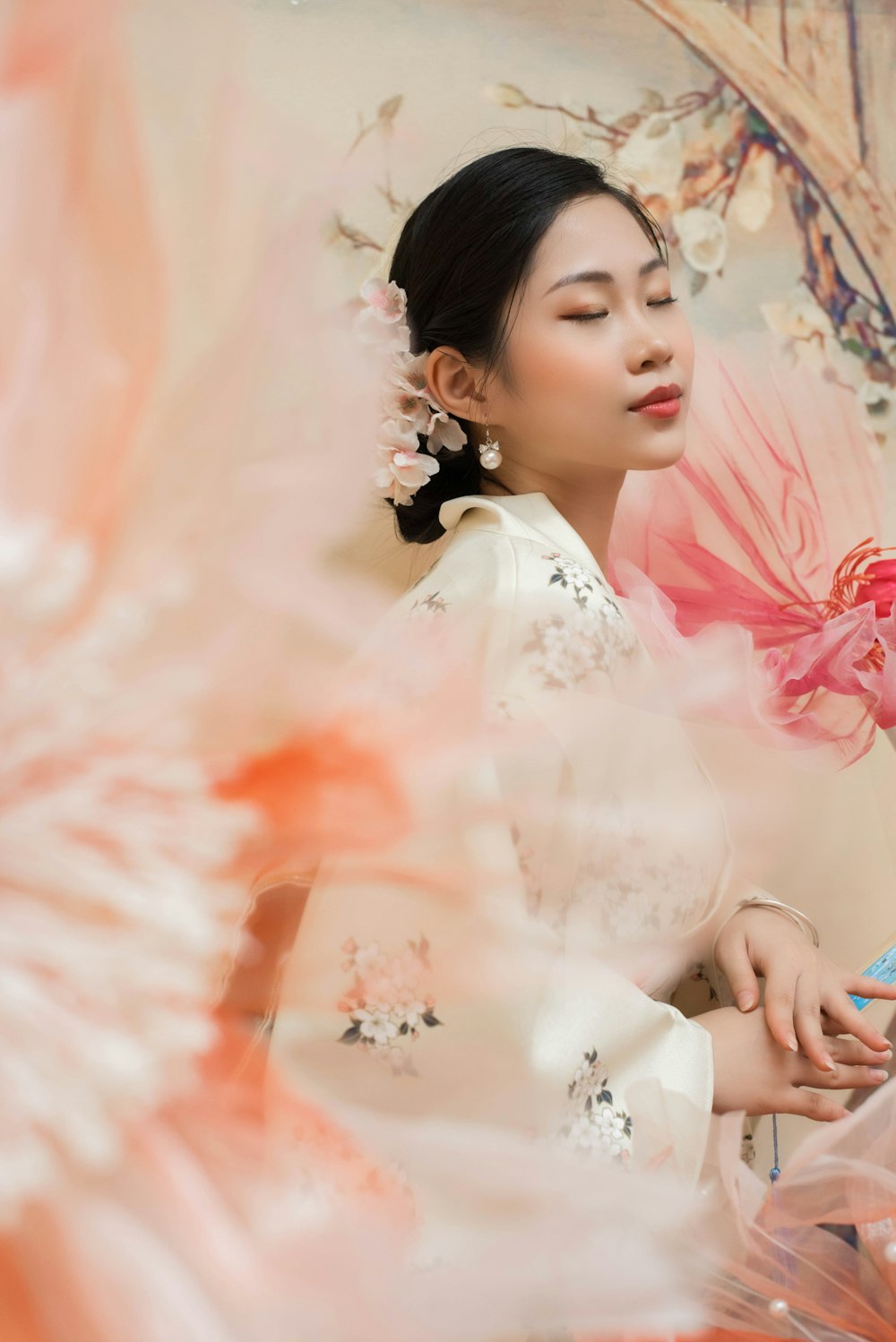 a woman in a white dress with a pink flower in her hair