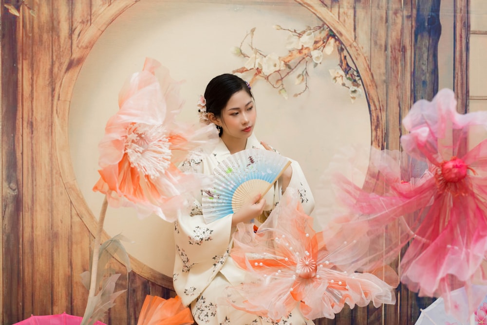 a woman in a kimono holding a fan