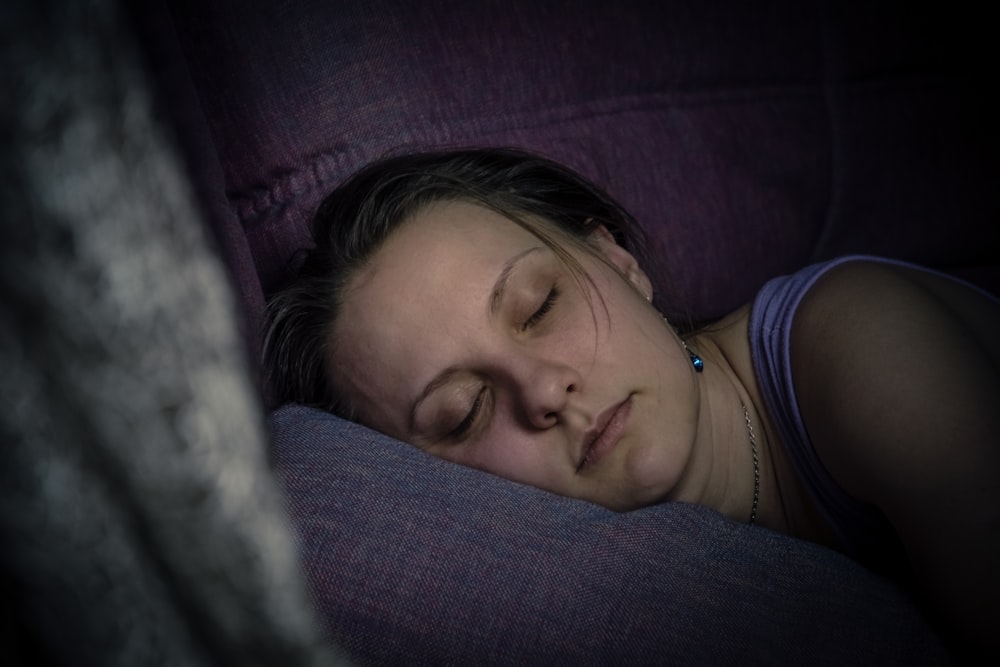 a woman sleeping on a couch with her eyes closed