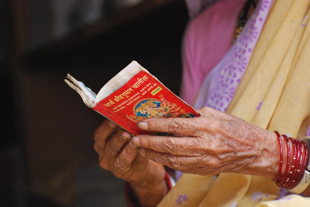 a woman holding a red book in her hands