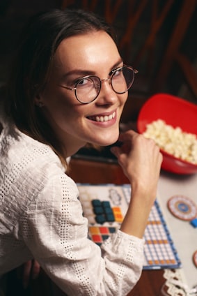 a woman sitting at a table with a bowl of popcorn