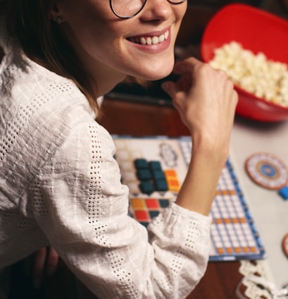 a woman sitting at a table with a bowl of popcorn