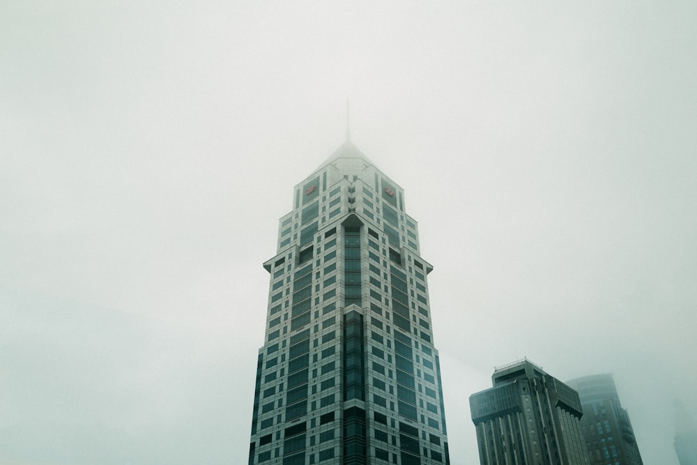 a very tall building in the middle of a foggy day