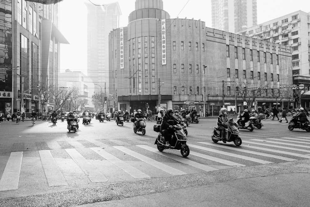 a group of people riding motorcycles down a street