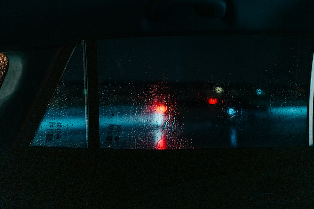 a view of a street through a car window at night