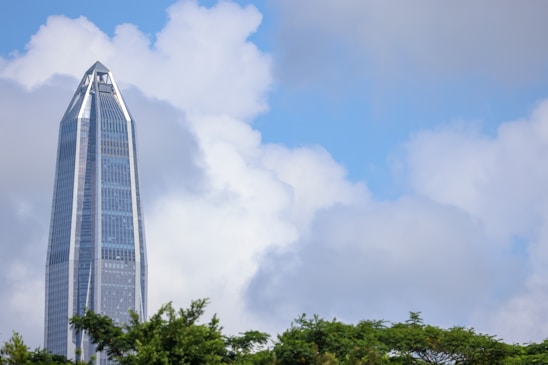 A sleek data center surrounded by lush green trees under a clear blue sky.