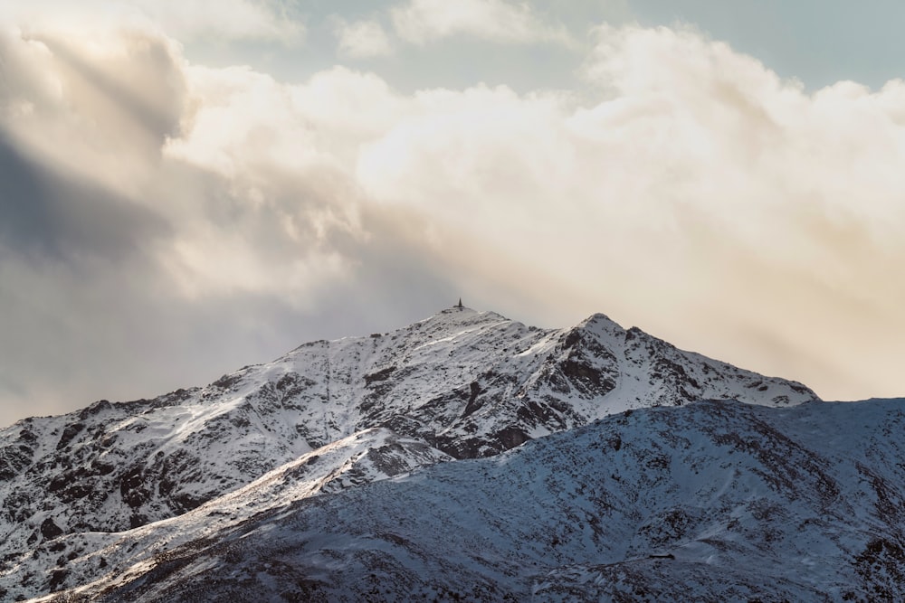 uma montanha coberta de neve sob um céu nublado