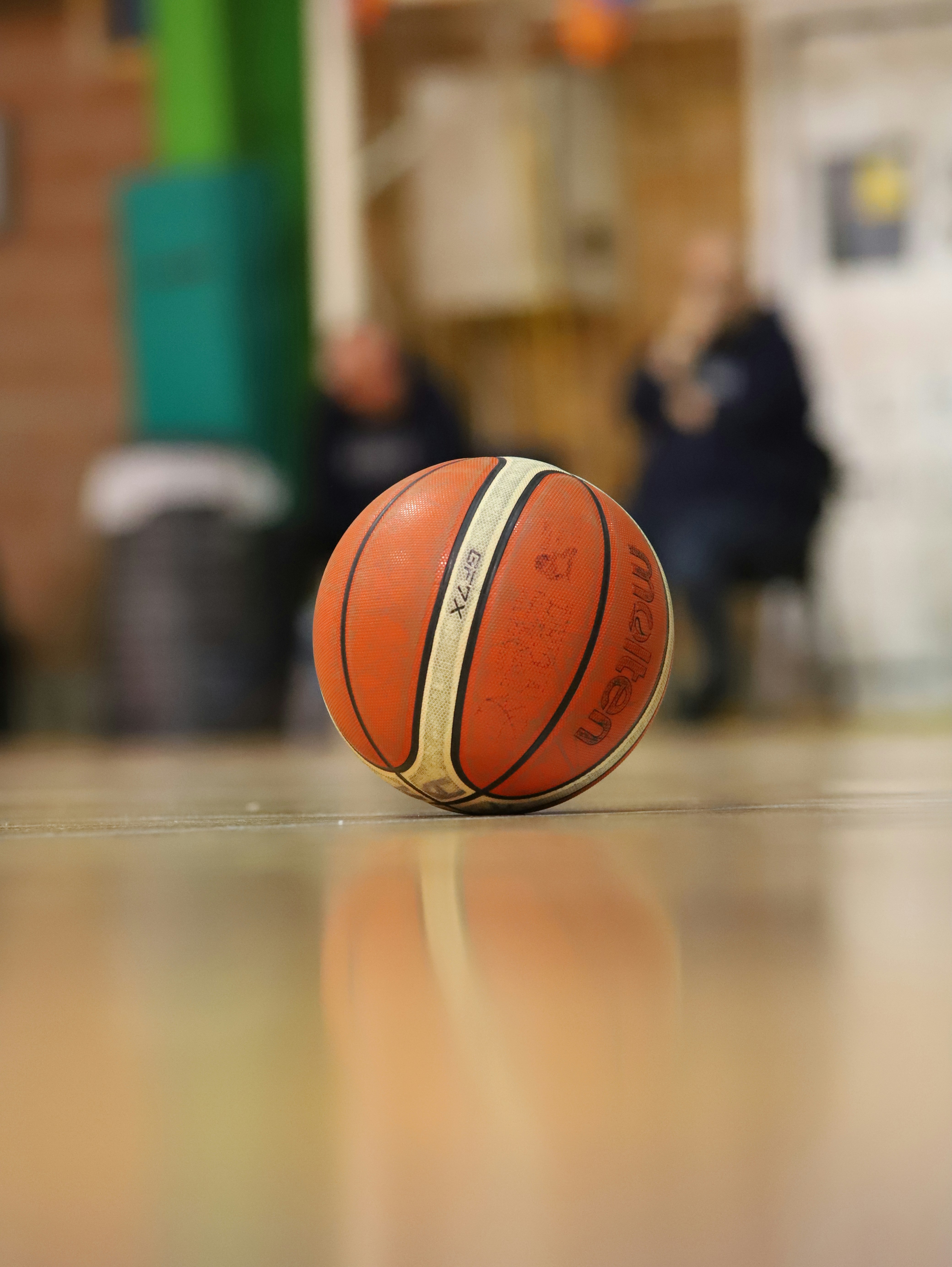 Ein Basketball sitzt auf dem Boden in einer Turnhalle