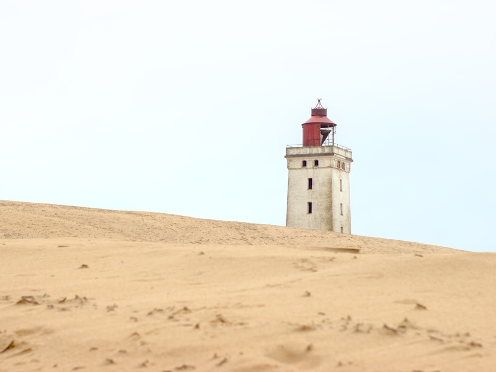 a lighthouse on top of a sandy hill