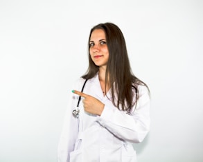 a woman in a white lab coat pointing at something