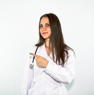 a woman in a white lab coat pointing at something