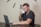 A man working on a laptop with a coffee cup beside him.
