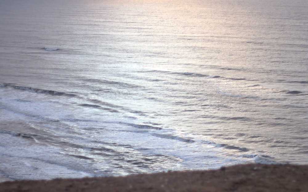 a person riding a surfboard on a wave covered beach