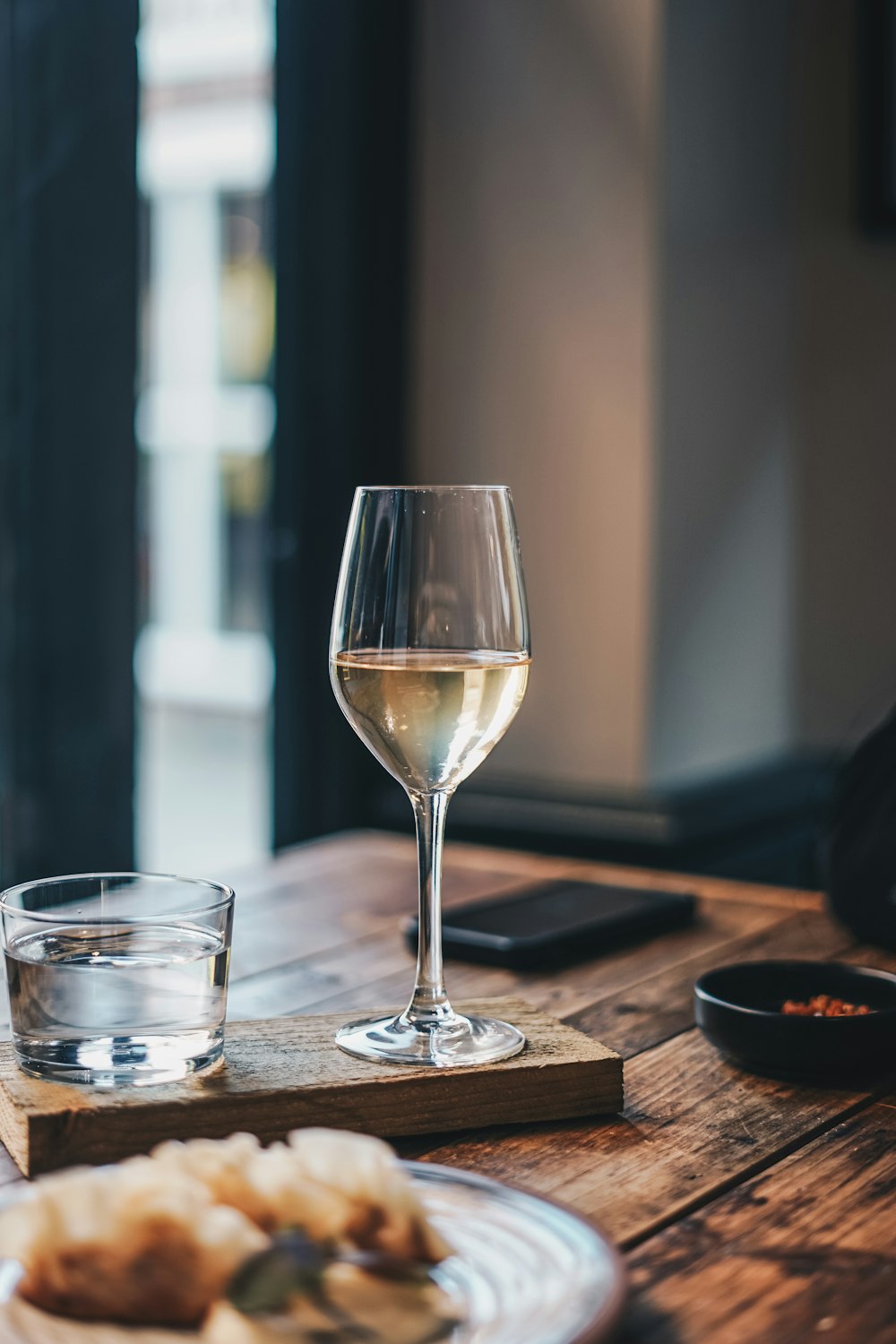 a plate of food and a glass of wine on a table