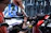 A smiling technician carefully tightening bolts on a home gym machine in a bright living room.