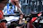 A smiling technician carefully tightening bolts on a home gym machine in a bright living room.